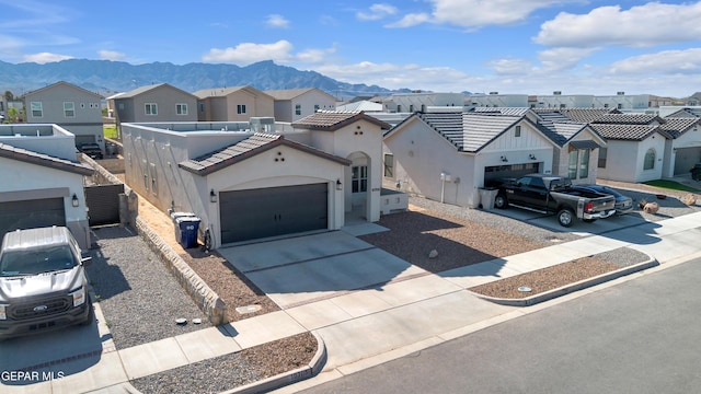 view of front of home featuring a residential view, driveway, stucco siding, a garage, and a mountain view