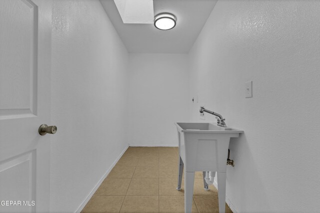 589 Gallagher St, El Paso, TX 79915 - washroom with light tile patterned floors, a skylight, and baseboards