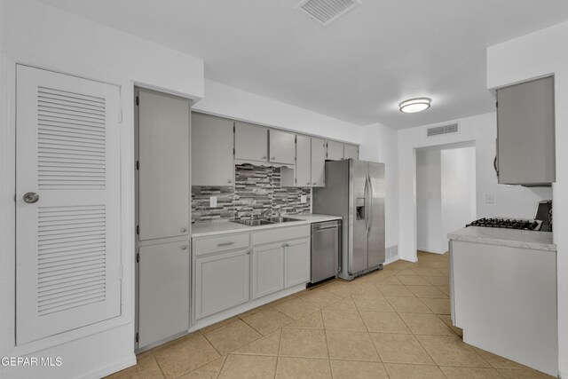 589 Gallagher St, El Paso, TX 79915 - kitchen featuring stainless steel appliances, a sink, backsplash, light countertops, and light tile patterned floors