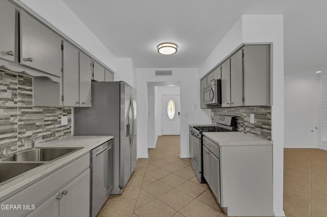 589 Gallagher St, El Paso, TX 79915 - kitchen with appliances with stainless steel finishes, light tile patterned floors, tasteful backsplash, and light countertops
