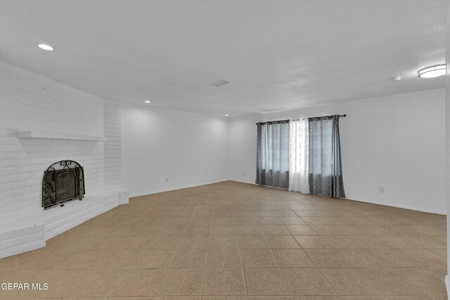 589 Gallagher St, El Paso, TX 79915 - unfurnished living room with recessed lighting, a brick fireplace, light tile patterned flooring, and baseboards