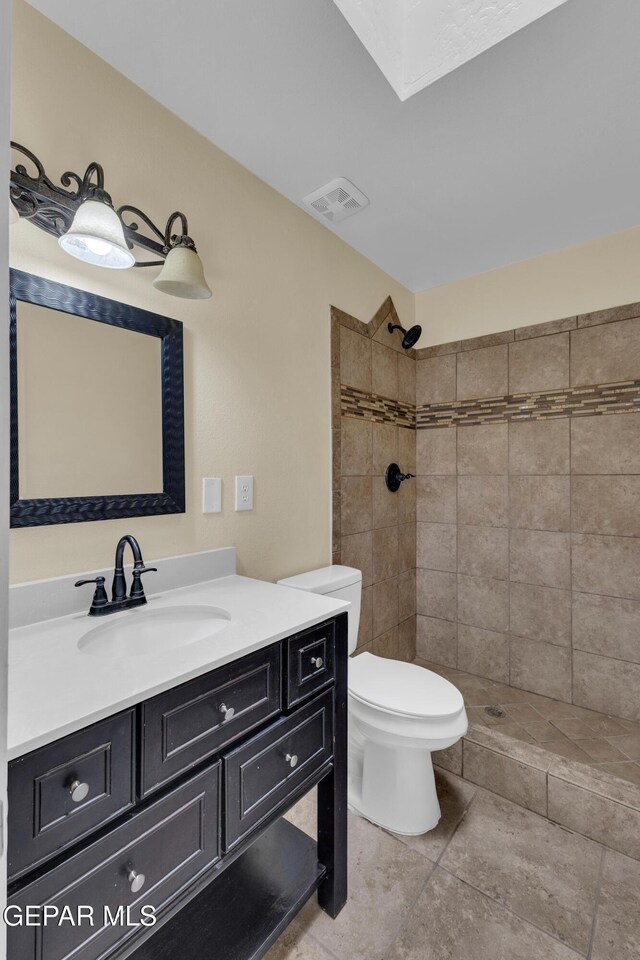 589 Gallagher St, El Paso, TX 79915 - full bath featuring a tile shower, toilet, vanity, a skylight, and tile patterned floors