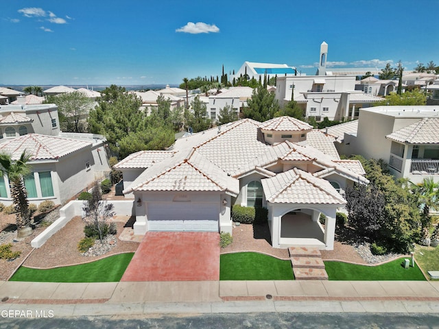 1483 Via Appia St, El Paso, TX 79912 - view of front of house with a residential view, a tiled roof, stucco siding, driveway, and an attached garage
