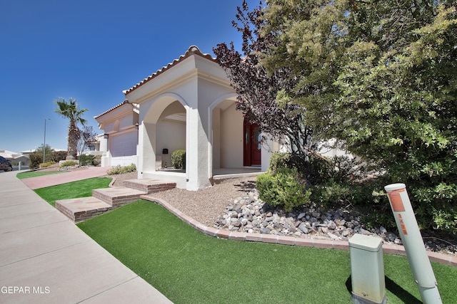 1483 Via Appia St, El Paso, TX 79912 - mediterranean / spanish home featuring an attached garage, stucco siding, a tile roof, a front yard, and driveway