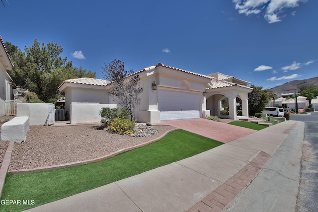 1483 Via Appia St, El Paso, TX 79912 - mediterranean / spanish-style home with decorative driveway, stucco siding, a garage, a tiled roof, and a gate