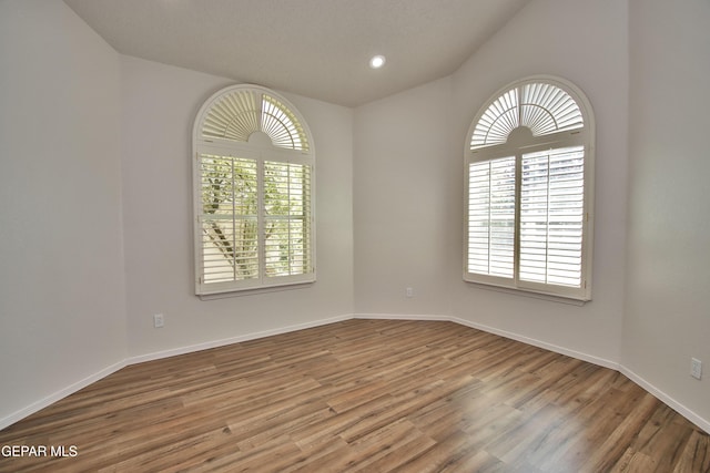 1483 Via Appia St, El Paso, TX 79912 - spare room with wood finished floors, lofted ceiling, baseboards, and recessed lighting