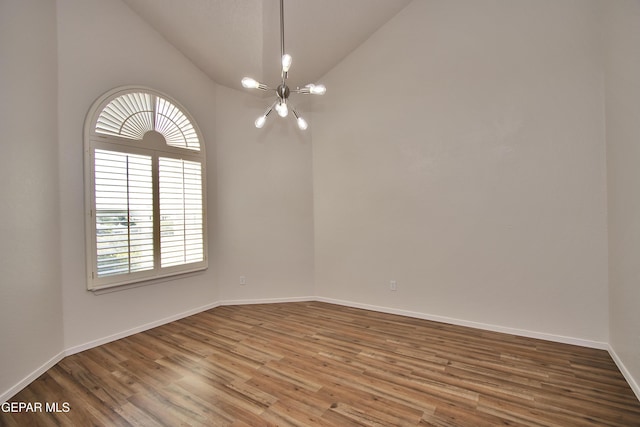 1483 Via Appia St, El Paso, TX 79912 - empty room featuring a chandelier, lofted ceiling, wood finished floors, and baseboards