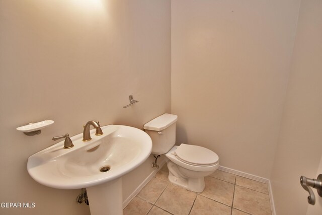 1483 Via Appia St, El Paso, TX 79912 - half bathroom with tile patterned floors, toilet, a sink, and baseboards