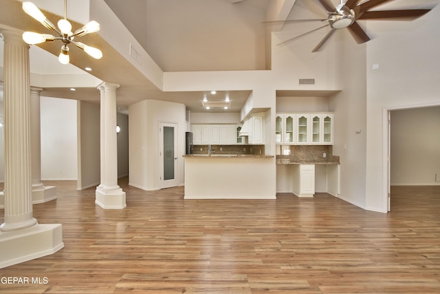 1483 Via Appia St, El Paso, TX 79912 - unfurnished living room with decorative columns, a towering ceiling, ceiling fan, light wood-type flooring, and baseboards