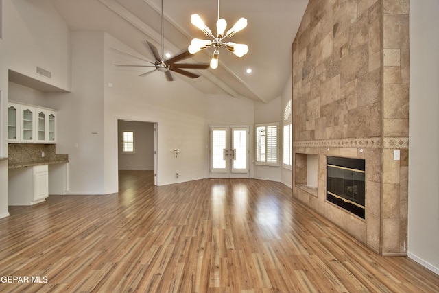 1483 Via Appia St, El Paso, TX 79912 - unfurnished living room with ceiling fan, light wood-style floors, a fireplace, plenty of natural light, and high vaulted ceiling