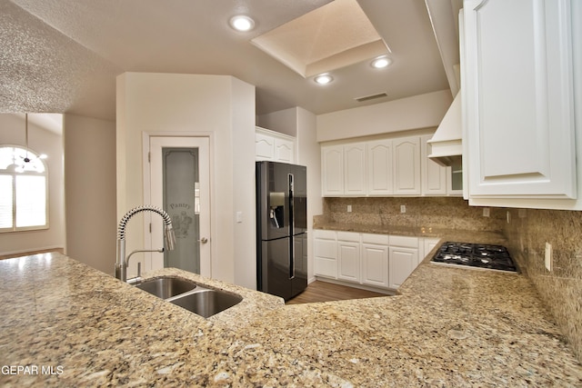 1483 Via Appia St, El Paso, TX 79912 - kitchen with refrigerator with ice dispenser, a sink, stainless steel gas cooktop, white cabinets, and backsplash