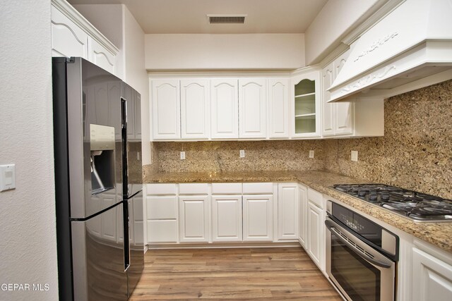 1483 Via Appia St, El Paso, TX 79912 - kitchen with stainless steel appliances, custom exhaust hood, and white cabinetry