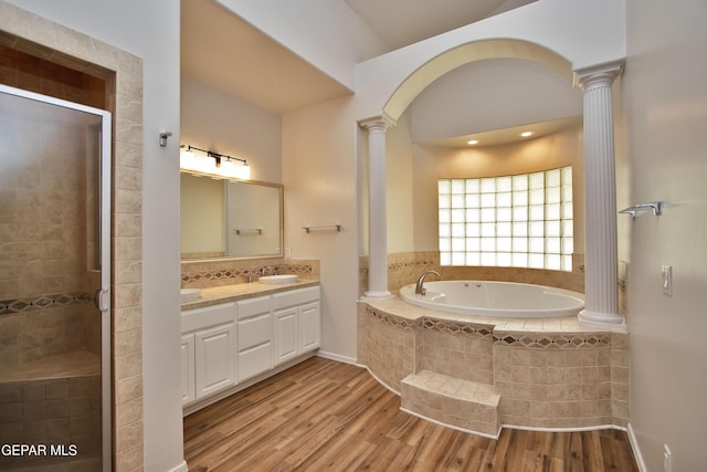 1483 Via Appia St, El Paso, TX 79912 - bathroom featuring decorative columns, wood finished floors, a stall shower, a bath, and vanity