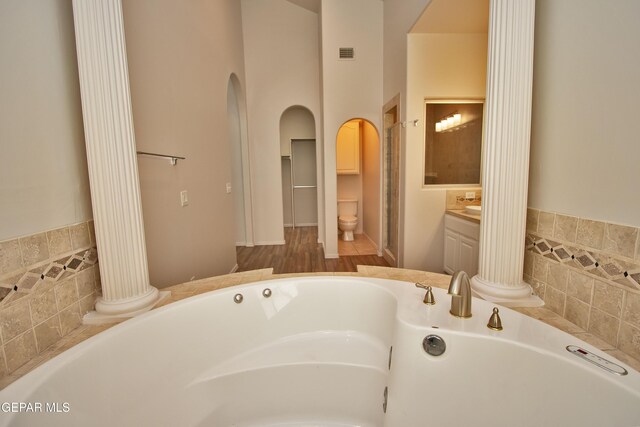 1483 Via Appia St, El Paso, TX 79912 - full bathroom with a garden tub, vanity, decorative columns, and a towering ceiling