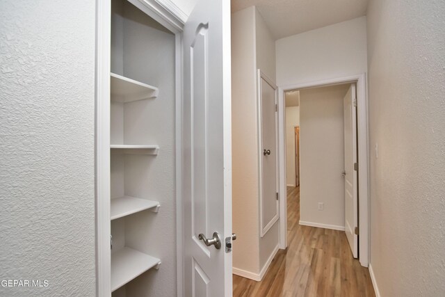 1483 Via Appia St, El Paso, TX 79912 - hall featuring wood finished floors, a textured wall, and baseboards