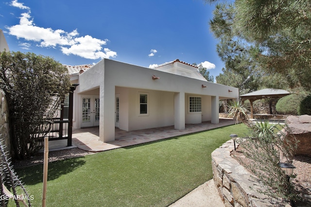 1483 Via Appia St, El Paso, TX 79912 - back of house featuring french doors, stucco siding, a tile roof, a patio area, and a lawn