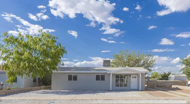 view of front of property with stucco siding and fence
