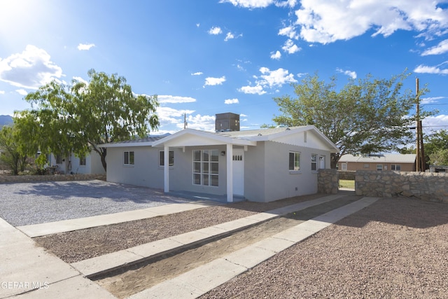 ranch-style home featuring fence, stucco siding, and a gate