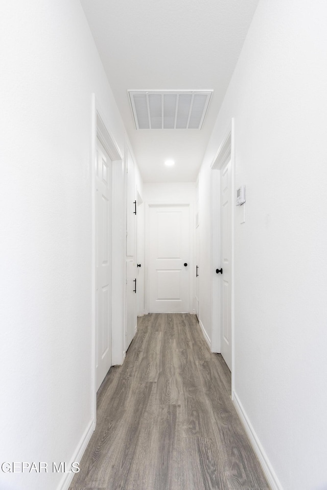 hall featuring wood finished floors and baseboards