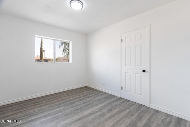 unfurnished room with wood finished floors and baseboards