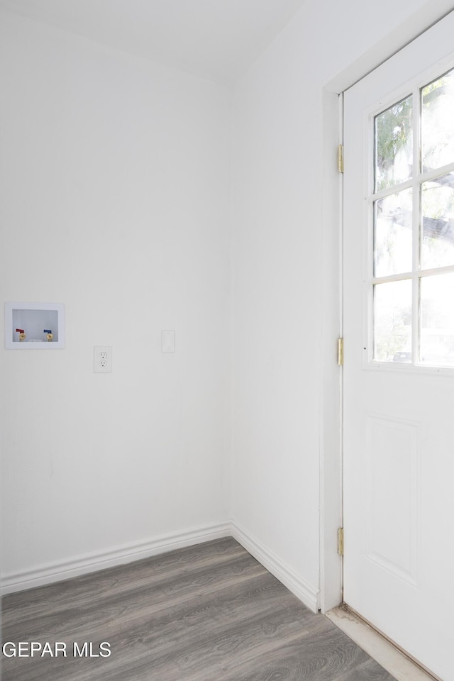 unfurnished room with healthy amount of natural light, wood finished floors, and baseboards