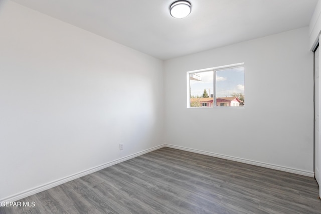 unfurnished room with wood finished floors and baseboards