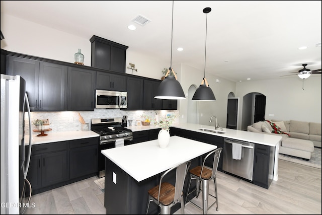 14844 Jack White Ave, El Paso, TX 79938 - kitchen with stainless steel appliances, a peninsula, open floor plan, decorative backsplash, and arched walkways