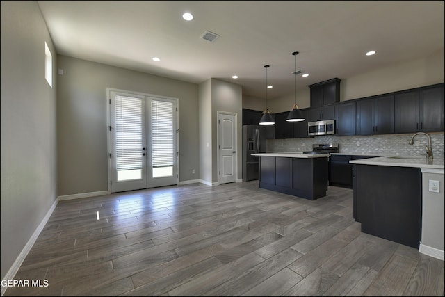 14844 Jack White Ave, El Paso, TX 79938 - kitchen featuring stainless steel microwave, a sink, refrigerator with ice dispenser, a kitchen island, and light countertops