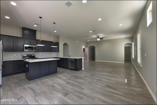 14844 Jack White Ave, El Paso, TX 79938 - kitchen featuring stainless steel appliances, arched walkways, open floor plan, a kitchen island, and ceiling fan