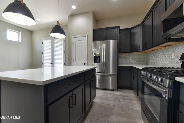 14844 Jack White Ave, El Paso, TX 79938 - kitchen with stainless steel appliances, light countertops, tasteful backsplash, hanging light fixtures, and a kitchen island