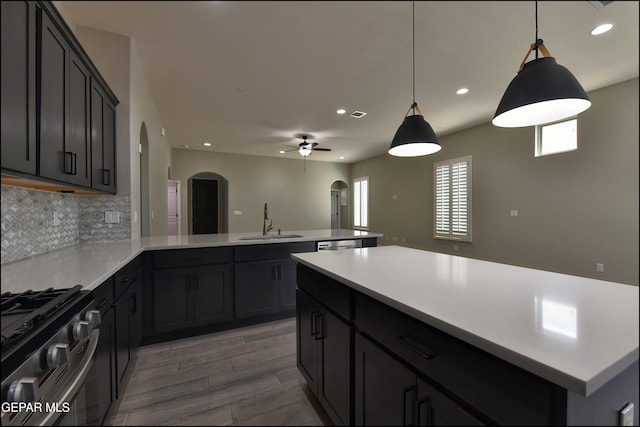 14844 Jack White Ave, El Paso, TX 79938 - kitchen with arched walkways, healthy amount of natural light, a peninsula, range with gas stovetop, and recessed lighting