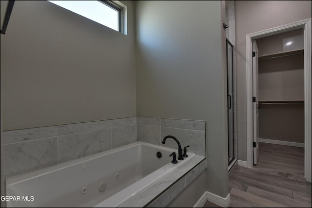 14844 Jack White Ave, El Paso, TX 79938 - full bath featuring a shower stall, a walk in closet, a tub with jets, wood finished floors, and baseboards