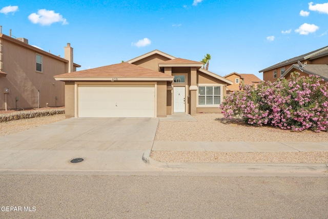 ranch-style home featuring stucco siding, an attached garage, and concrete driveway