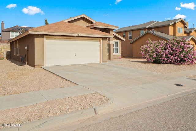 view of front of property with stucco siding, an attached garage, and concrete driveway