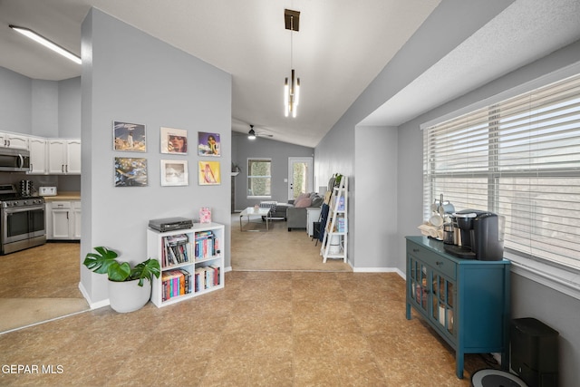 hallway featuring light floors, lofted ceiling, and baseboards