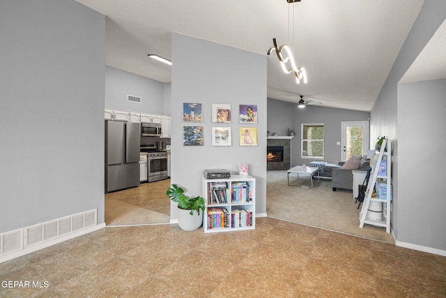 hallway with vaulted ceiling, baseboards, and light flooring