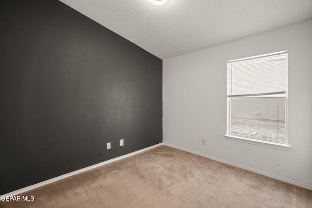 carpeted empty room with lofted ceiling and baseboards
