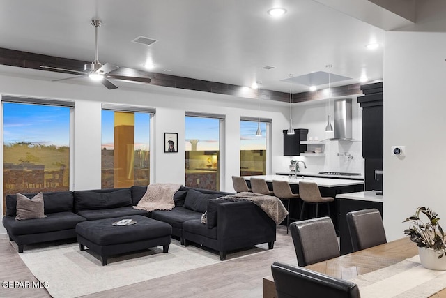 living room with light wood-style floors and a ceiling fan