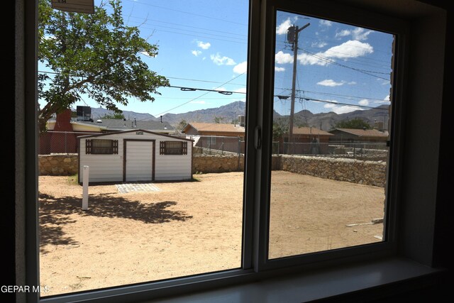 9207 Montgomery Dr, El Paso, TX 79924 - fenced backyard featuring a mountain view, a storage unit, and an outdoor structure