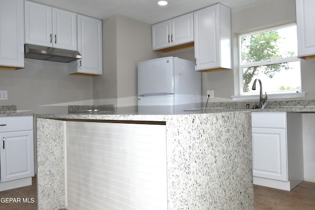 9207 Montgomery Dr, El Paso, TX 79924 - kitchen with under cabinet range hood, freestanding refrigerator, tile patterned floors, a sink, and recessed lighting