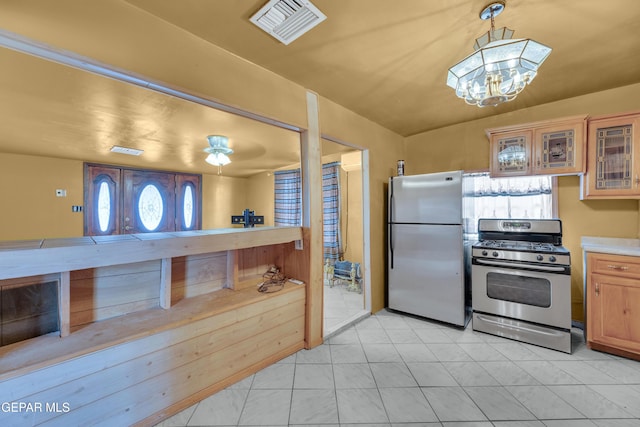 3571 Rebecca Ln, El Paso, TX 79938 - kitchen with appliances with stainless steel finishes, glass insert cabinets, a chandelier, light tile patterned floors, and light countertops