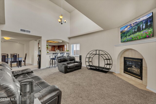 living area with carpet, a fireplace, arched walkways, baseboards, and a high ceiling