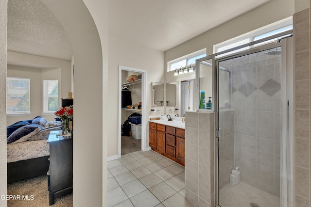 full bathroom with ensuite bathroom, a shower stall, vanity, and tile patterned floors