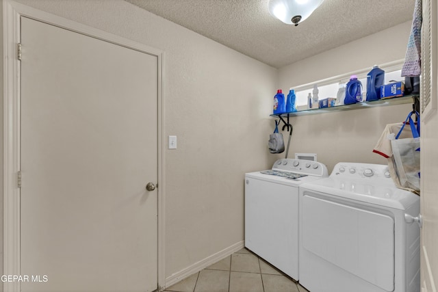 washroom with separate washer and dryer, a textured ceiling, light tile patterned flooring, and baseboards