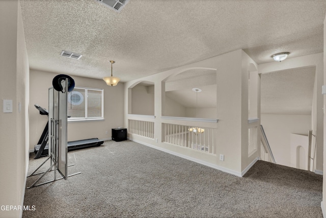 workout area with carpet floors, a textured ceiling, and baseboards