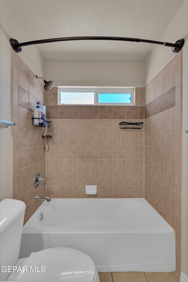 full bath featuring toilet, tile patterned floors, and washtub / shower combination