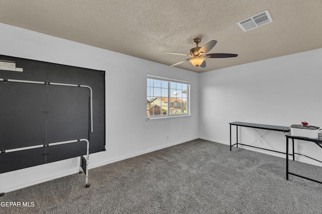 unfurnished office with carpet flooring, ceiling fan, a textured ceiling, and baseboards