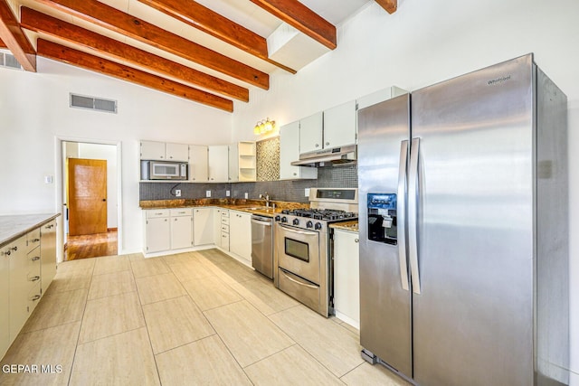 8024 Tonto Pl, El Paso, TX 79904 - kitchen featuring stainless steel appliances, under cabinet range hood, beamed ceiling, tasteful backsplash, and high vaulted ceiling