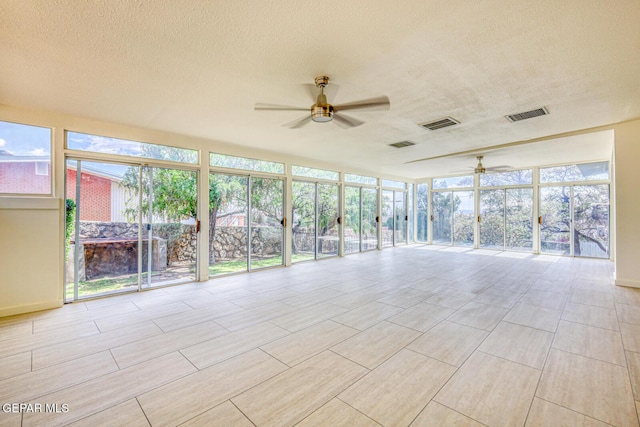 8024 Tonto Pl, El Paso, TX 79904 - unfurnished sunroom with a ceiling fan, a textured ceiling, floor to ceiling windows, and baseboards