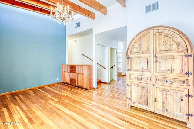 8024 Tonto Pl, El Paso, TX 79904 - spare room featuring a high ceiling, a chandelier, beamed ceiling, light wood-style floors, and baseboards